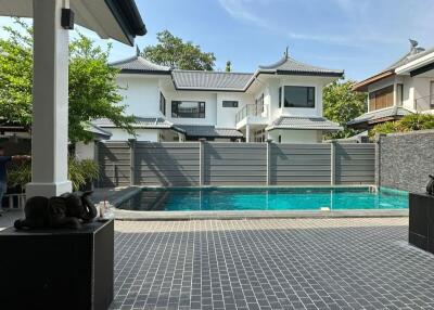 View of a backyard with a swimming pool and adjacent houses