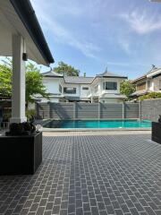 View of a backyard with a swimming pool and adjacent houses