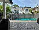 View of a backyard with a swimming pool and adjacent houses