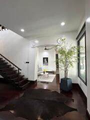 Front entrance view into living area with staircase and indoor plant