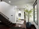 Front entrance view into living area with staircase and indoor plant