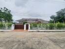 Front view of the house with surrounding wall and gate