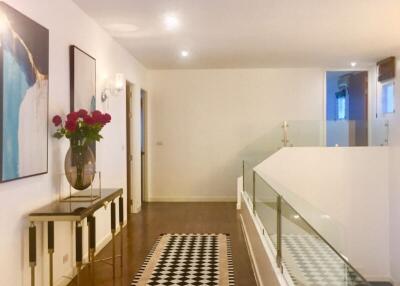 Modern hallway with wooden floor and glass railing