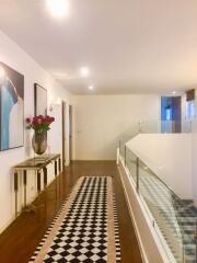 Modern hallway with wooden floor and glass railing