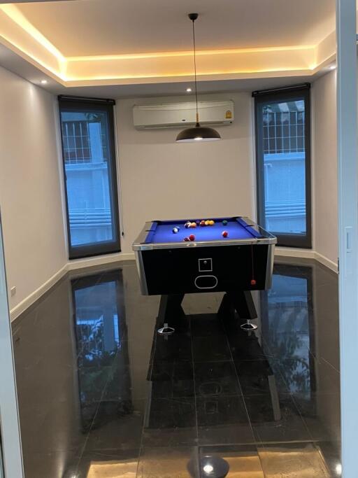 Indoor recreational room with a pool table and modern lighting