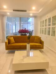 Spacious living room with a yellow sofa and large windows