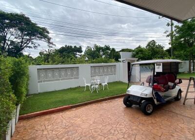 Outdoor garden area with seating and a golf cart