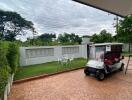 Outdoor garden area with seating and a golf cart