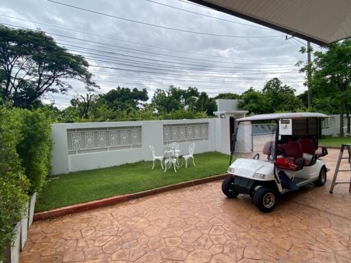 Outdoor garden area with seating and a golf cart