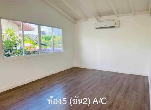 Spacious bedroom with large window and air conditioning