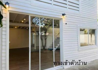 Exterior view of home with sliding glass doors and white siding