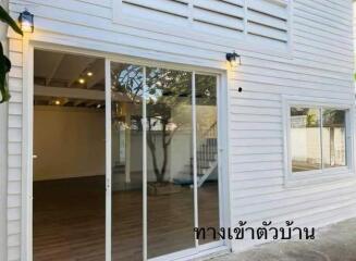 Exterior view of home with sliding glass doors and white siding