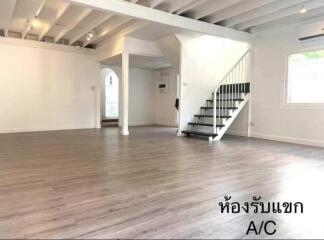 Spacious living room with wooden flooring and staircase