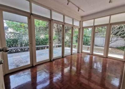 Spacious, well-lit living room with hardwood flooring and large windows