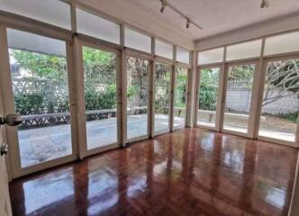 Spacious, well-lit living room with hardwood flooring and large windows