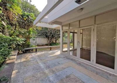 Spacious patio area with greenery and glass doors