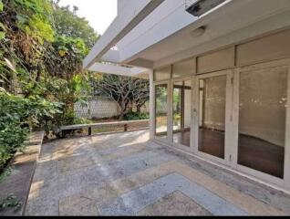 Spacious patio area with greenery and glass doors