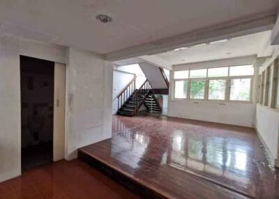 Spacious living room with large windows and staircase