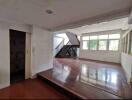 Spacious living room with large windows and staircase