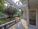 Photo of a backyard with a patio area, trees, and surrounding greenery.