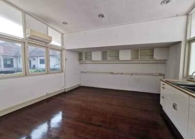 Spacious, unfurnished kitchen with hardwood floors and large windows