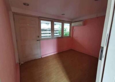 Empty bedroom with wooden floor and pink walls