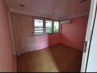 Empty bedroom with wooden floor and pink walls