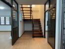 Staircase area with glass doors and wooden flooring