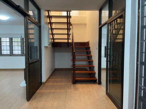 Staircase area with glass doors and wooden flooring