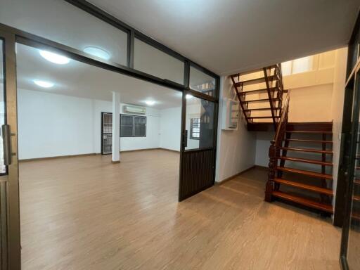 Spacious living area with wooden flooring and staircase