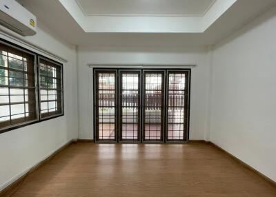 Spacious living room with wooden flooring and large windows