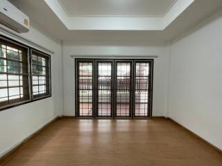 Spacious living room with wooden flooring and large windows