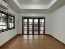 Spacious living room with wooden flooring and large windows