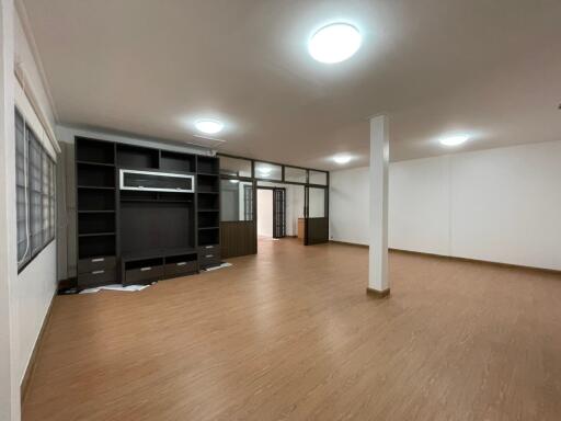 Spacious main living area with hardwood flooring and built-in shelving