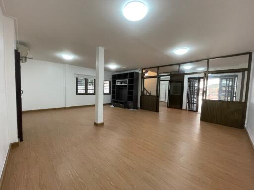 Spacious living room with wooden flooring and ample lighting