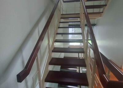 Interior view of modern staircase with wooden steps and railing