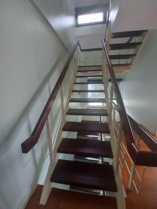 Interior view of modern staircase with wooden steps and railing