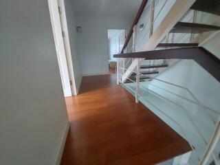 Modern hallway with wooden flooring and staircase