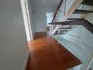 Modern hallway with wooden flooring and staircase