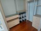 Spacious walk-in closet with wooden flooring and built-in storage units