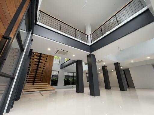 Modern open-concept living area with high ceilings and mezzanine