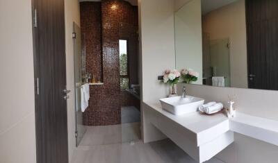 Modern bathroom with tiled shower and large mirror