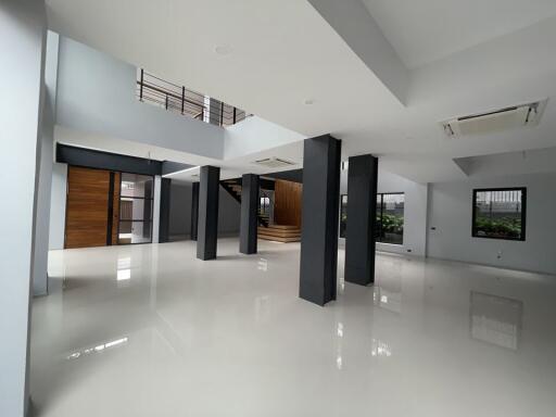 Spacious modern indoor area with columns and a staircase