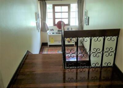 Upper-floor staircase landing leading to desk area with window