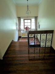 Upper-floor staircase landing leading to desk area with window