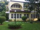 Exterior view of a yellow two-story house with windows and landscaping