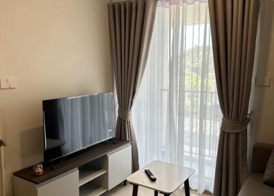 Cozy living room with TV, air conditioner, and balcony view