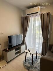 Cozy living room with TV, air conditioner, and balcony view