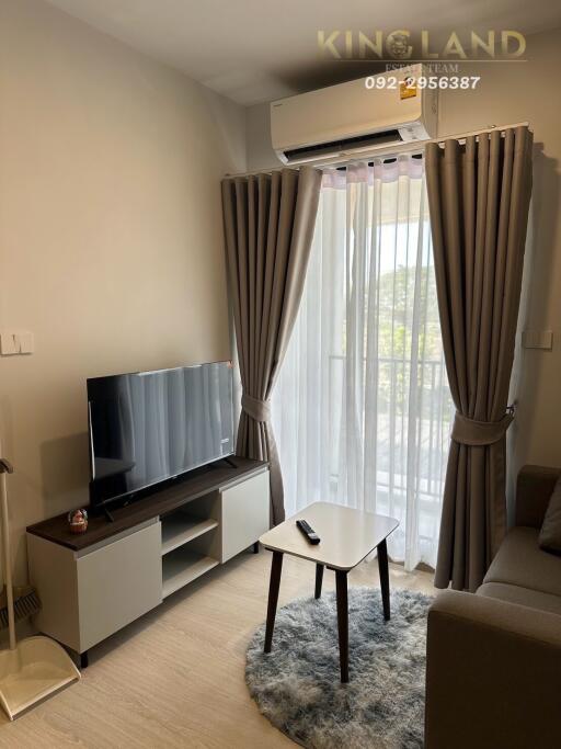 Cozy living room with TV, air conditioner, and balcony view