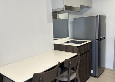 Compact modern kitchen area with dining table and chairs